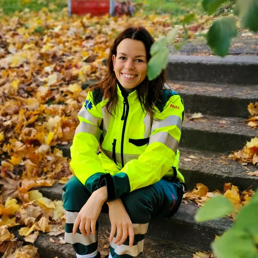 Ambulance nurse Linnea wearing high-visibility workwear outdoors.