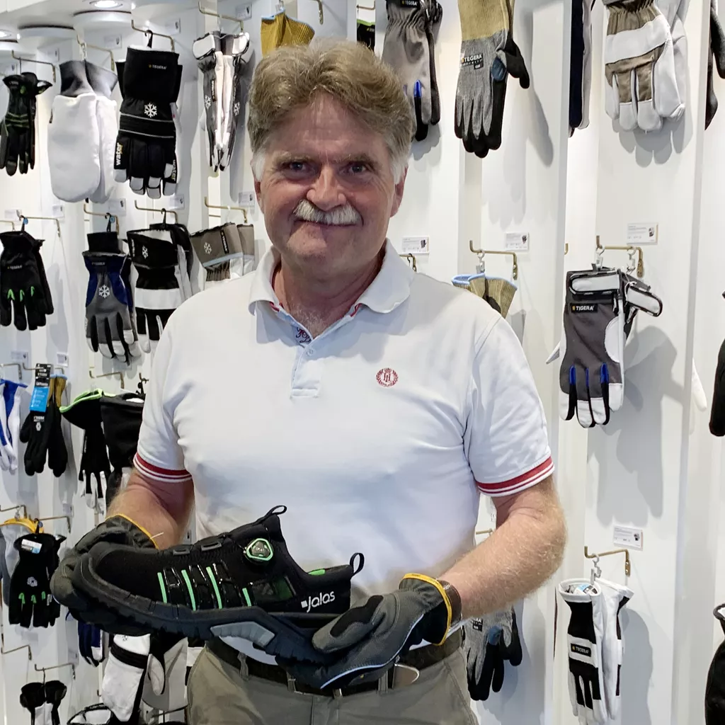 Samuel Enqvist holding a JALAS safety shoe in the Ejendals showroom.