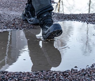 JALAS 1288 GTX safety shoes walking through a puddle in wet conditions